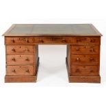 A mahogany pedestal desk, the leather inset top above an arrangement of nine drawers,