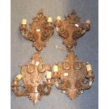 A set of four carved walnut two branch wall lights,