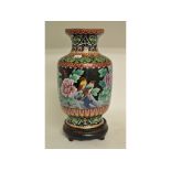 A cloisonné vase, decorated birds, flowers and foliage, on a carved hardwood stand,