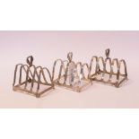 A pair of silver four division toast racks, Birmingham 1937, 7 cm high, another similar,