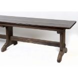 An oak refectory table, on three legs united by a plain stretcher,