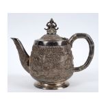An Indian silver coloured metal teapot and hinged cover,
