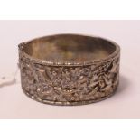 A Chinese silver coloured metal bangle, decorated stylised sea creatures,