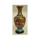 A cloisonné vase, decorated flowers and foliage, slight loss, on a hardwood stand,