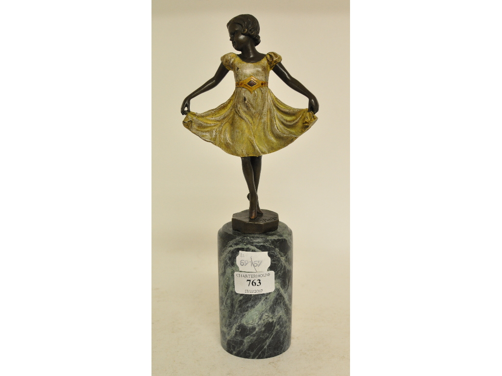 A painted metal figure of a girl in a dress, on a marble base,