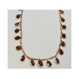 A yellow coloured metal and oval garnet drop necklace Condition report Report by