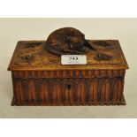 A Continental carved fruitwood box and hinged cover, the cover surmounted a sleeping dog,
