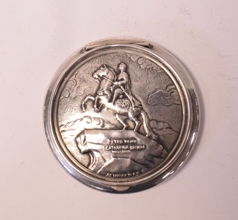 A Russian silver coloured metal compact, decorated The Bronze Horseman Monument,