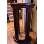 A French oval display cabinet, with a marble inset top, on brass paw feet,