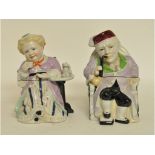 A pair of novelty pottery tobacco jars, in the form of a seated lady and gentleman,