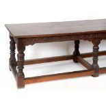 A 17th century style oak refectory table, the freize carved lunettes,