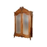 A French walnut armoire, the cornice carved a shell, flowers and foliage,