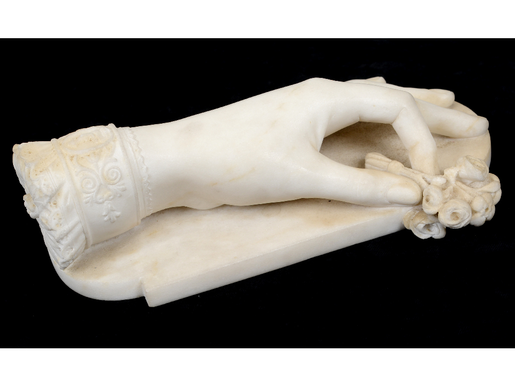 A 19th century marble paperweight, modelled as a hand holding a small bunch of flowers,