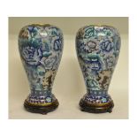 A pair of cloisonné vases, with blue floral decoration, on carved hardwood stands,