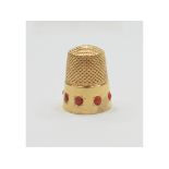 A yellow coloured metal thimble, set coral, approx. 7.