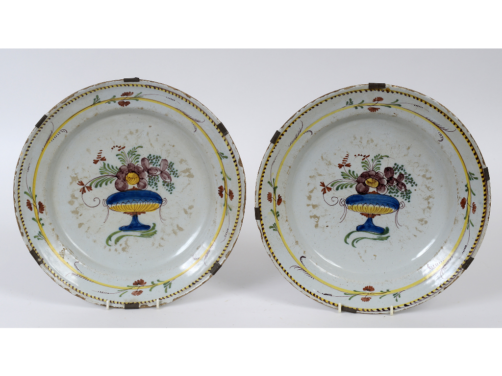 A pair of Delft chargers, decorated flowers in polychrome colours, both on wire hangers,