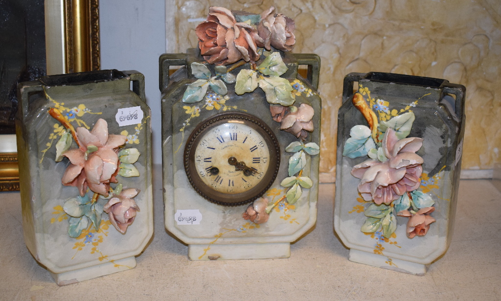 A 19th century pottery clock garniture, decorated flowers, the clock 29.