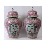 Two large Chinese porcelain famille rose vases and covers, decorated birds, flowers, and foliage,