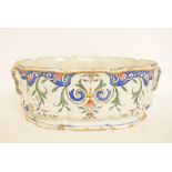 A 19th century tin glazed jardiniere, of shaped oval form, decorated flowers and foliage, cracked,