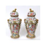 A pair of Cantonese porcelain famille rose vases and covers,