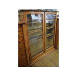 An oak glazed bookcase, having four adju