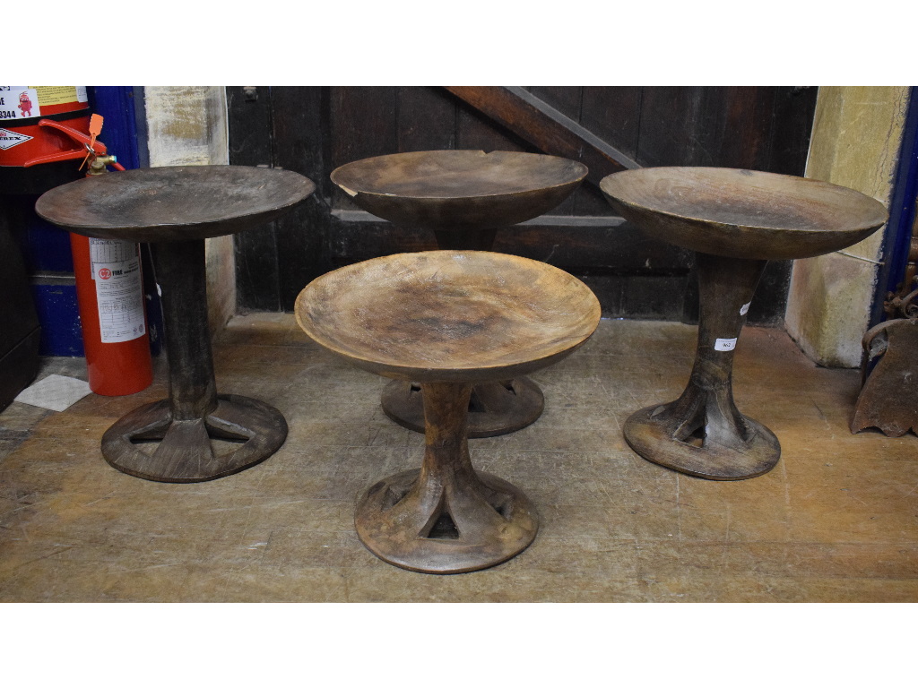 A set of four African tribal carved wood circular occasional tables, possibly Nagaland, 41 cm wide