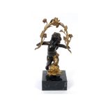 A bronze putto, with gilt decoration on