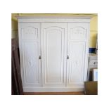 A white painted triple wardrobe, decorat