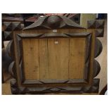 A carved wood trampwork mirror frame, 10