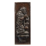 A CARVED OAK PANEL OF A FIGURE KNEELING IN PRAYER