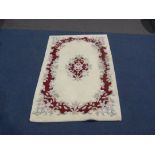 This is a Timed Online Auction on Bidspotter.co.uk, Click here to bid. A cream & red floral rug (