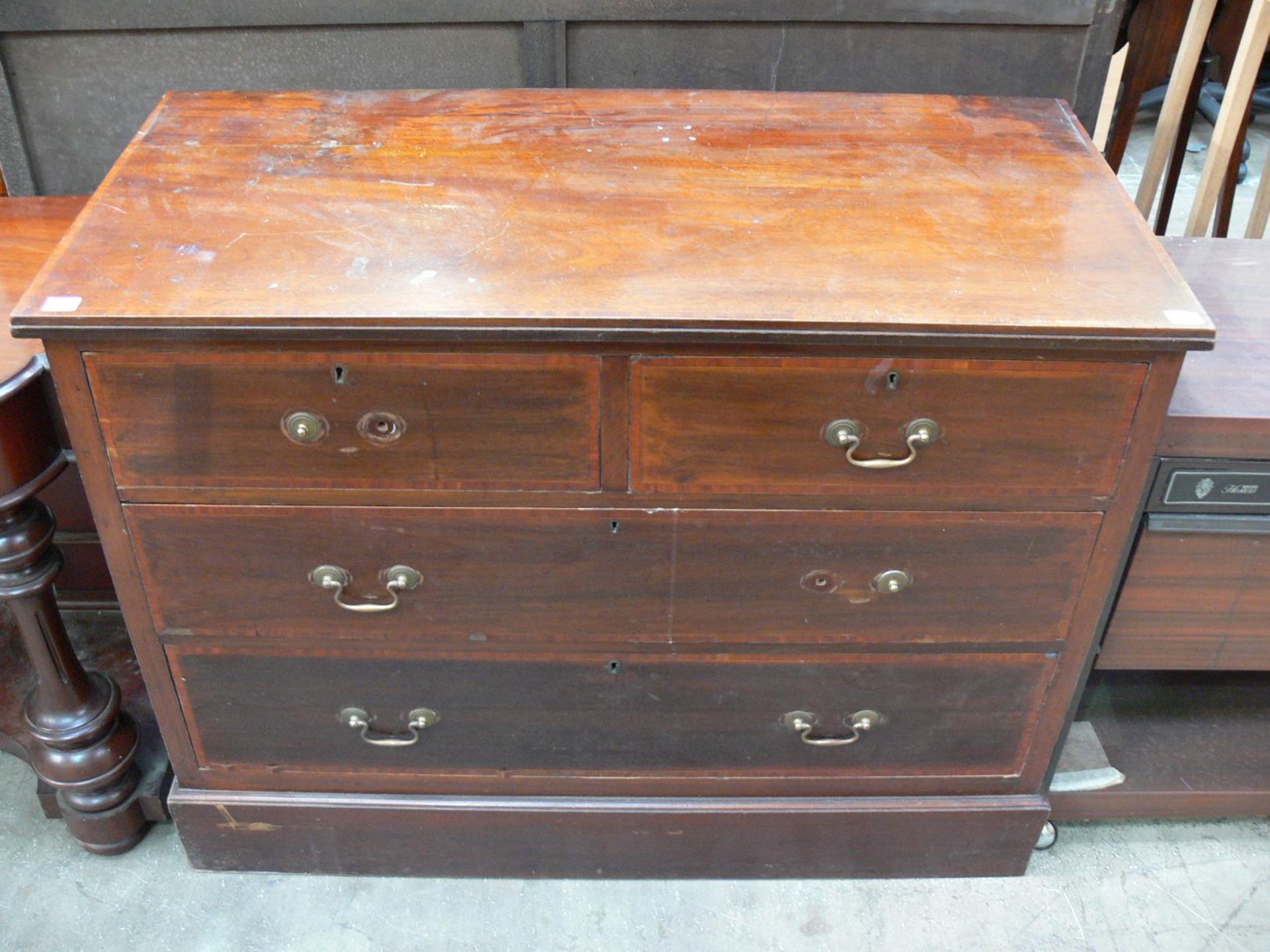 A mahogany chest of four drawers with metal drop handles (H82cm W108cm D51cm) (est £70-£90)