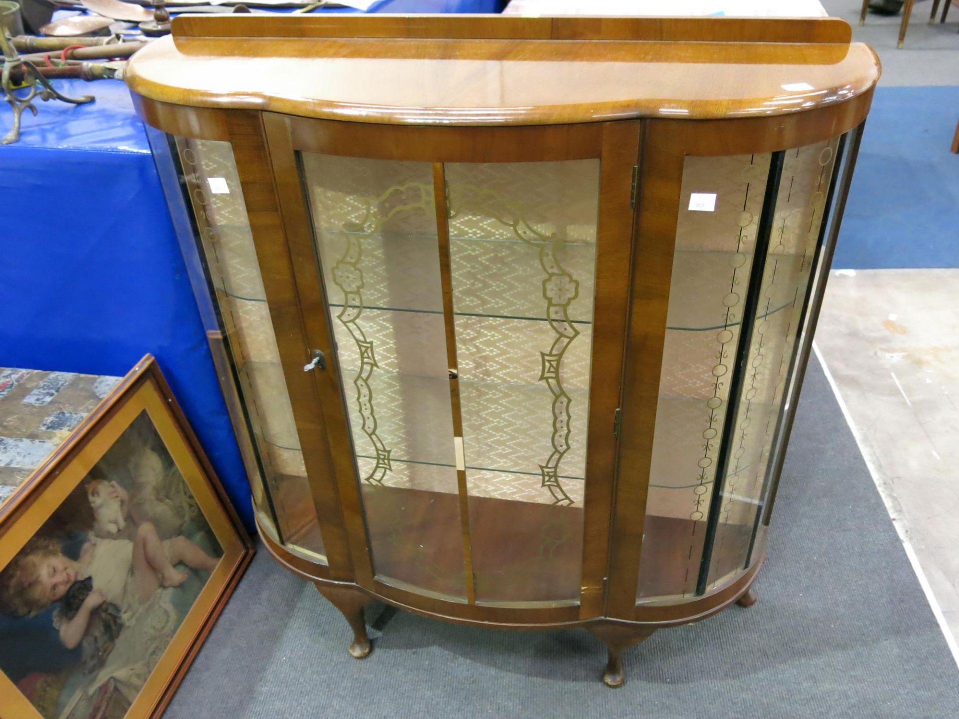 A decorated glass panelled display cabinet with two shaped glass shelves (H115cm W104cm D34cm) (