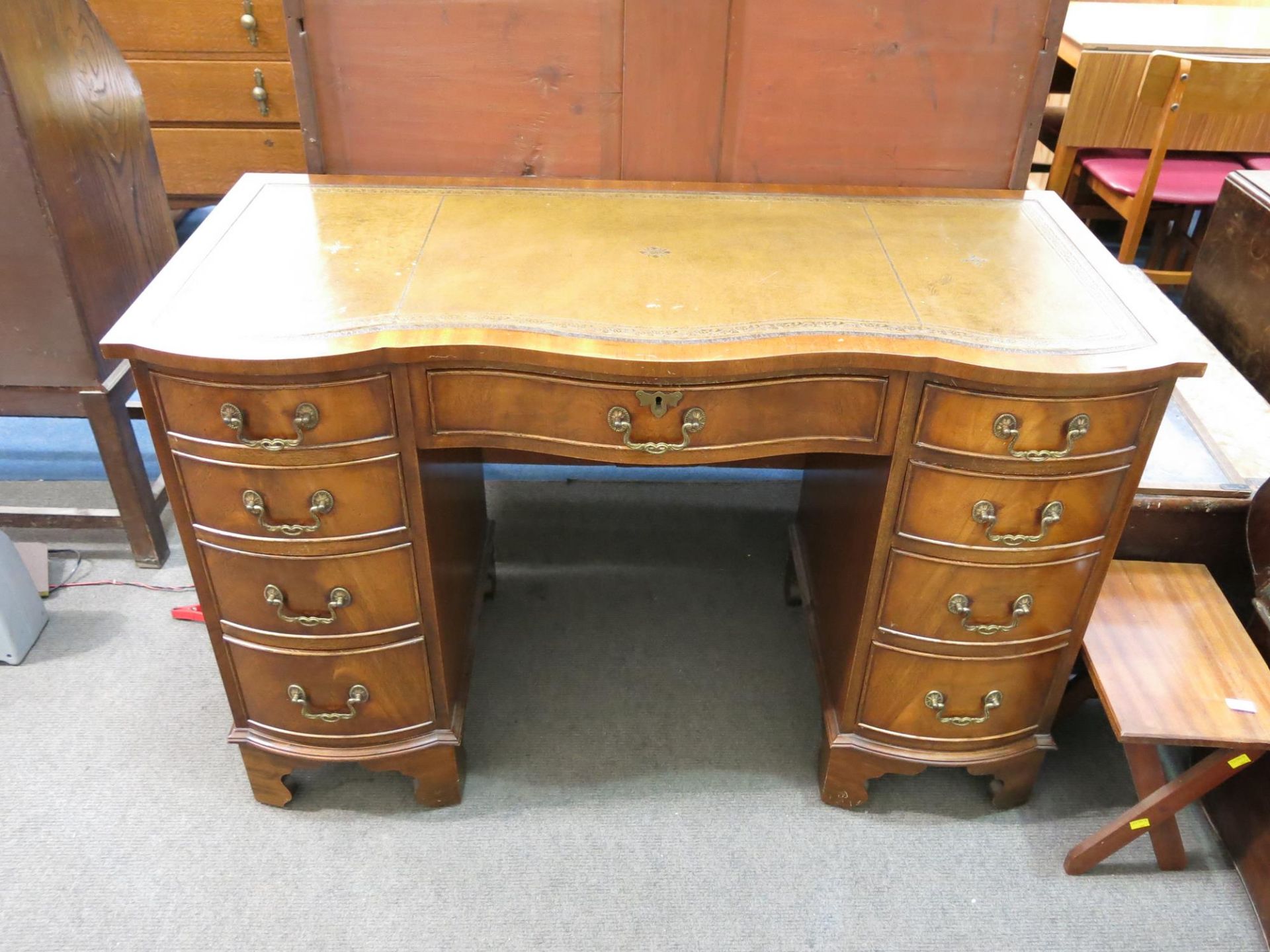 A pedestal desk with nine drawers and leather inlaid writing surface (H 76cm, W 115cm, D 52cm) (