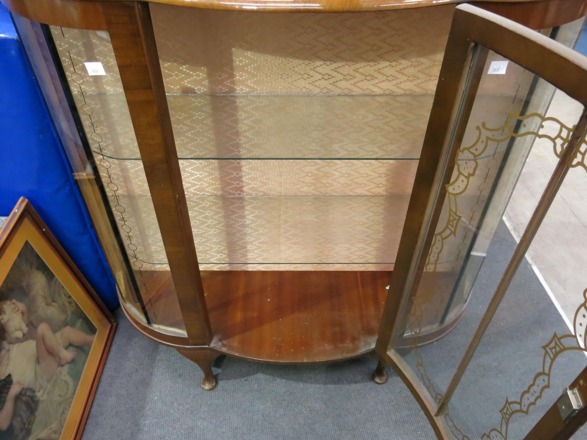 A decorated glass panelled display cabinet with two shaped glass shelves (H115cm W104cm D34cm) ( - Image 2 of 2