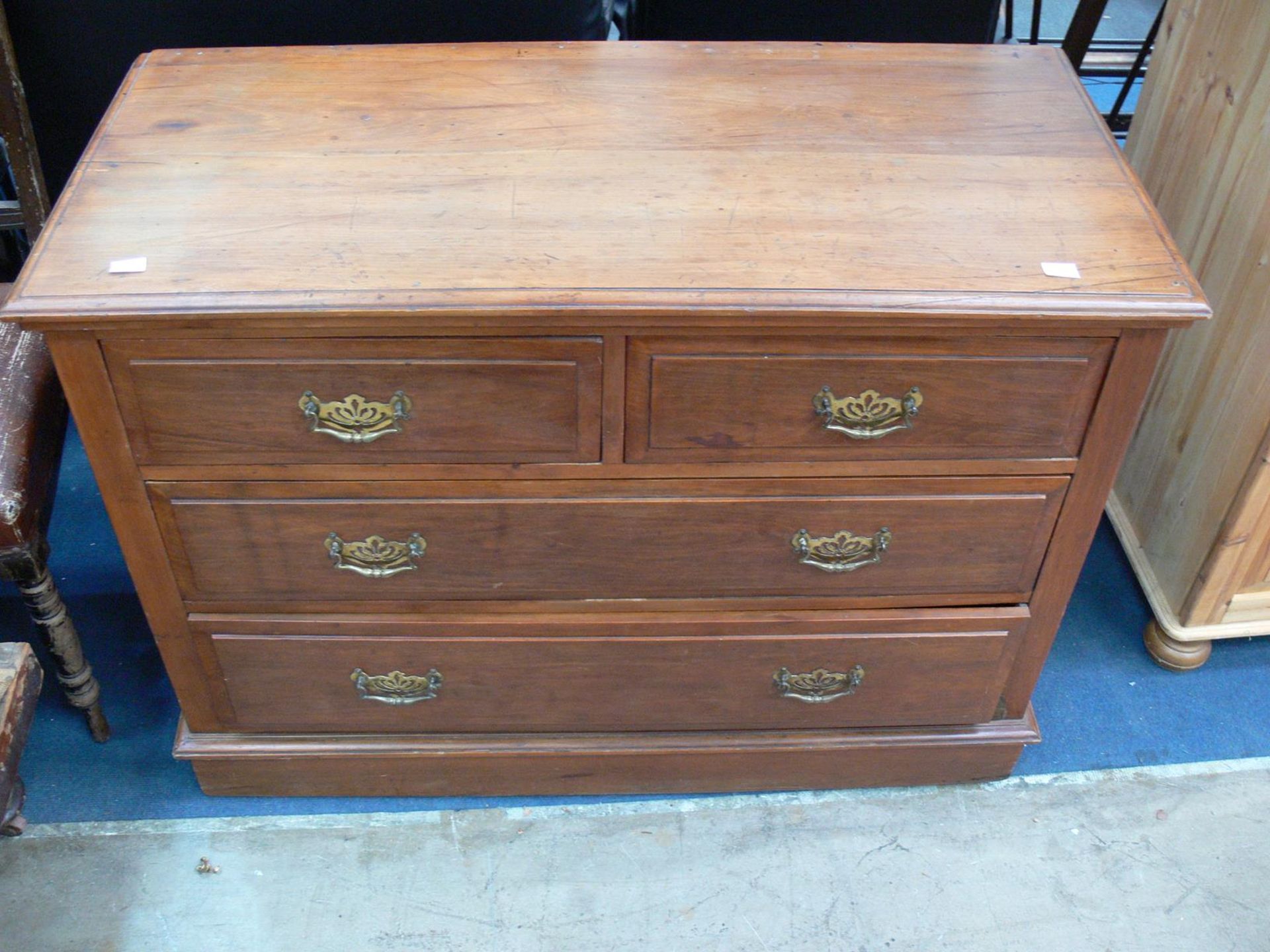 A chest of four drawers with metal drop down handles (H78cm W106cm D50cm) (est £30-£60)