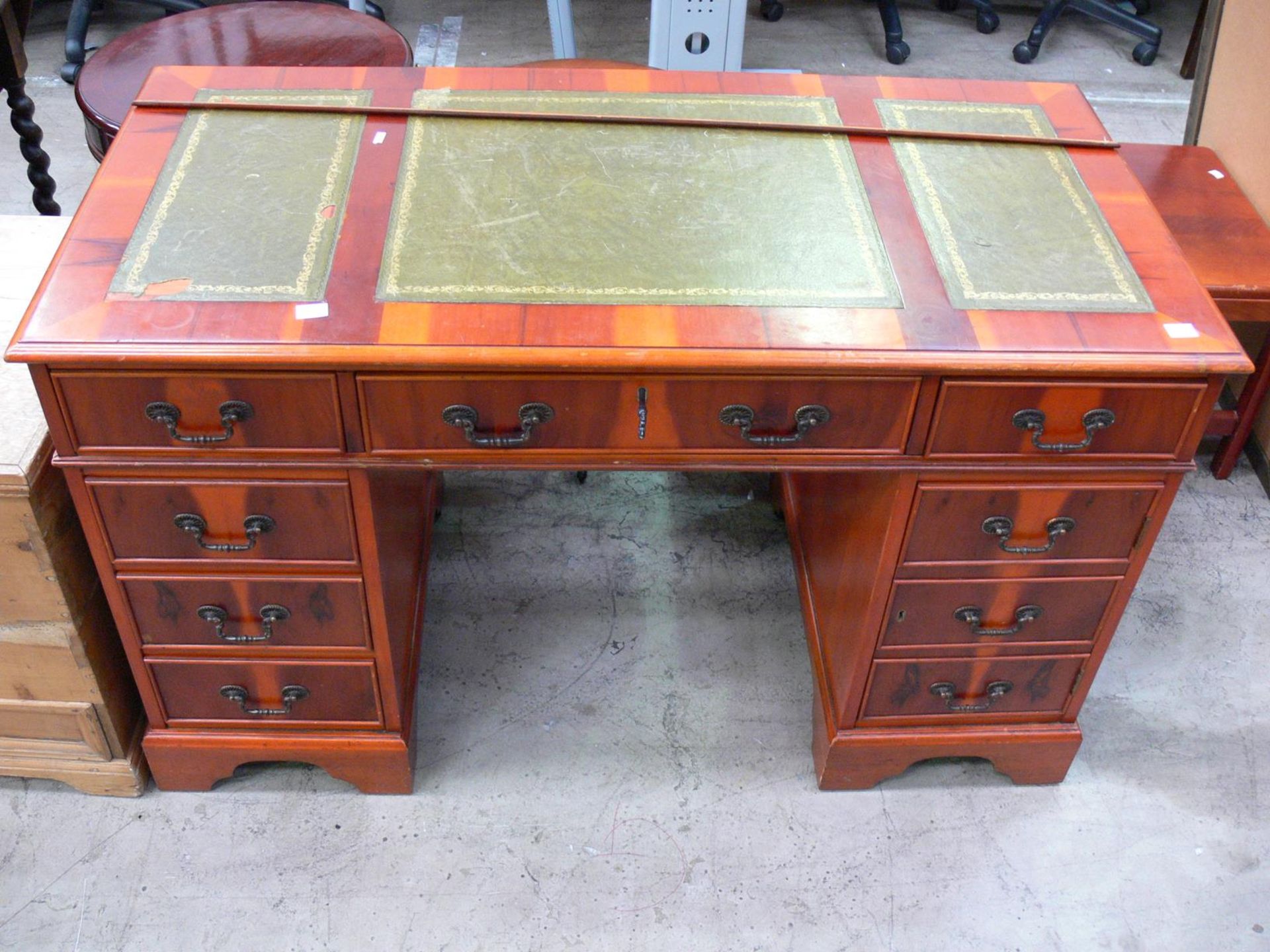 A modern pedestal desk with a column of four drawers, central drawer, single drawer above cupboard