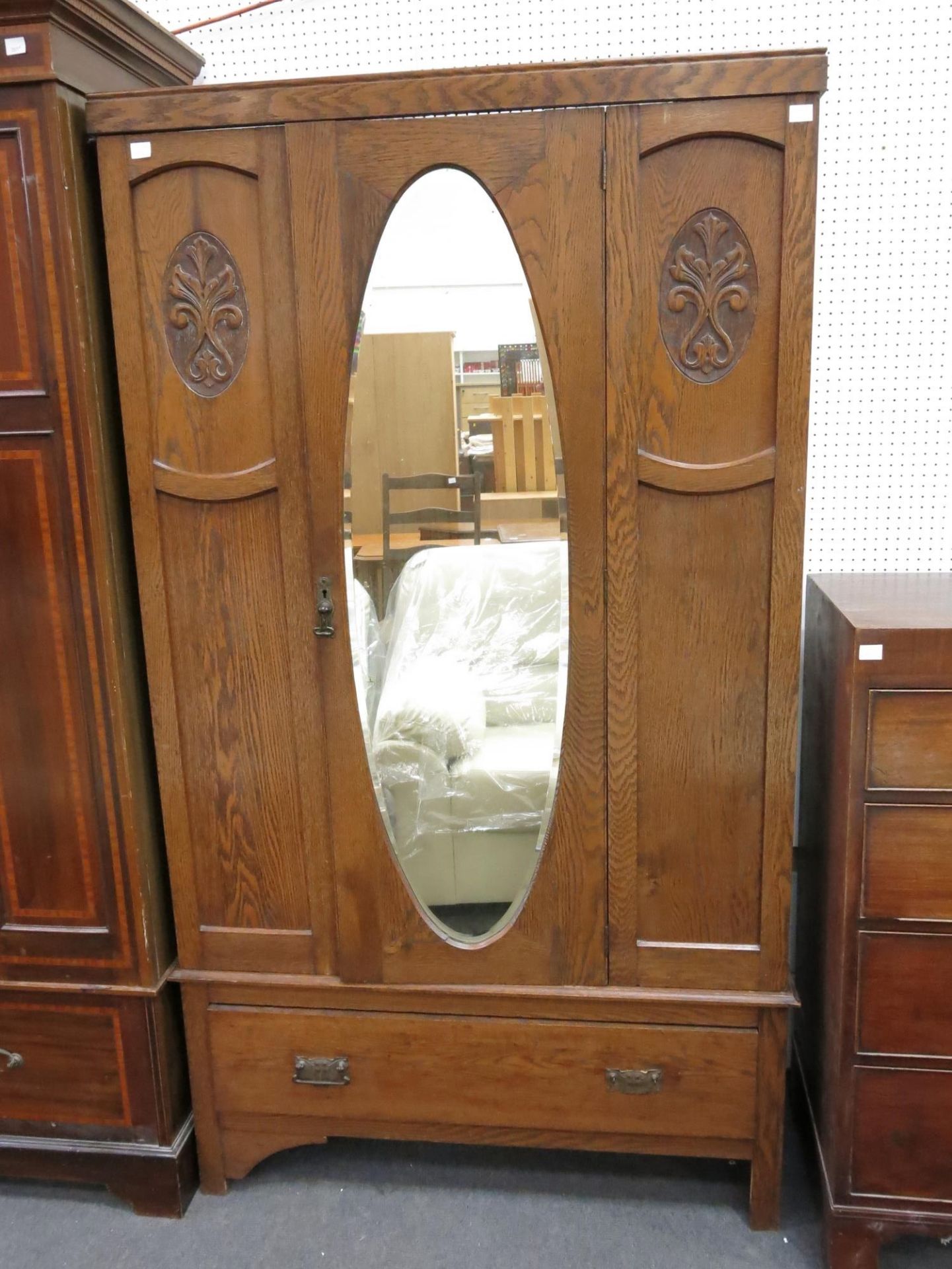 An oak wardrobe with mirror door over single drawer (Height-186cm, Width- 104.5cm, Diameter-