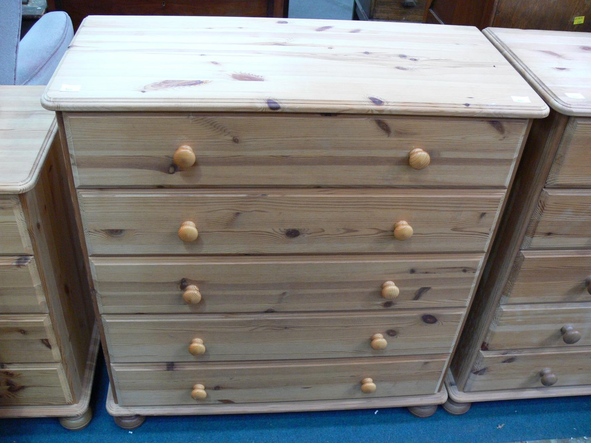 A pine chest of five drawers on bun feet (H89cm W83cm D39cm) (est £25-£50)
