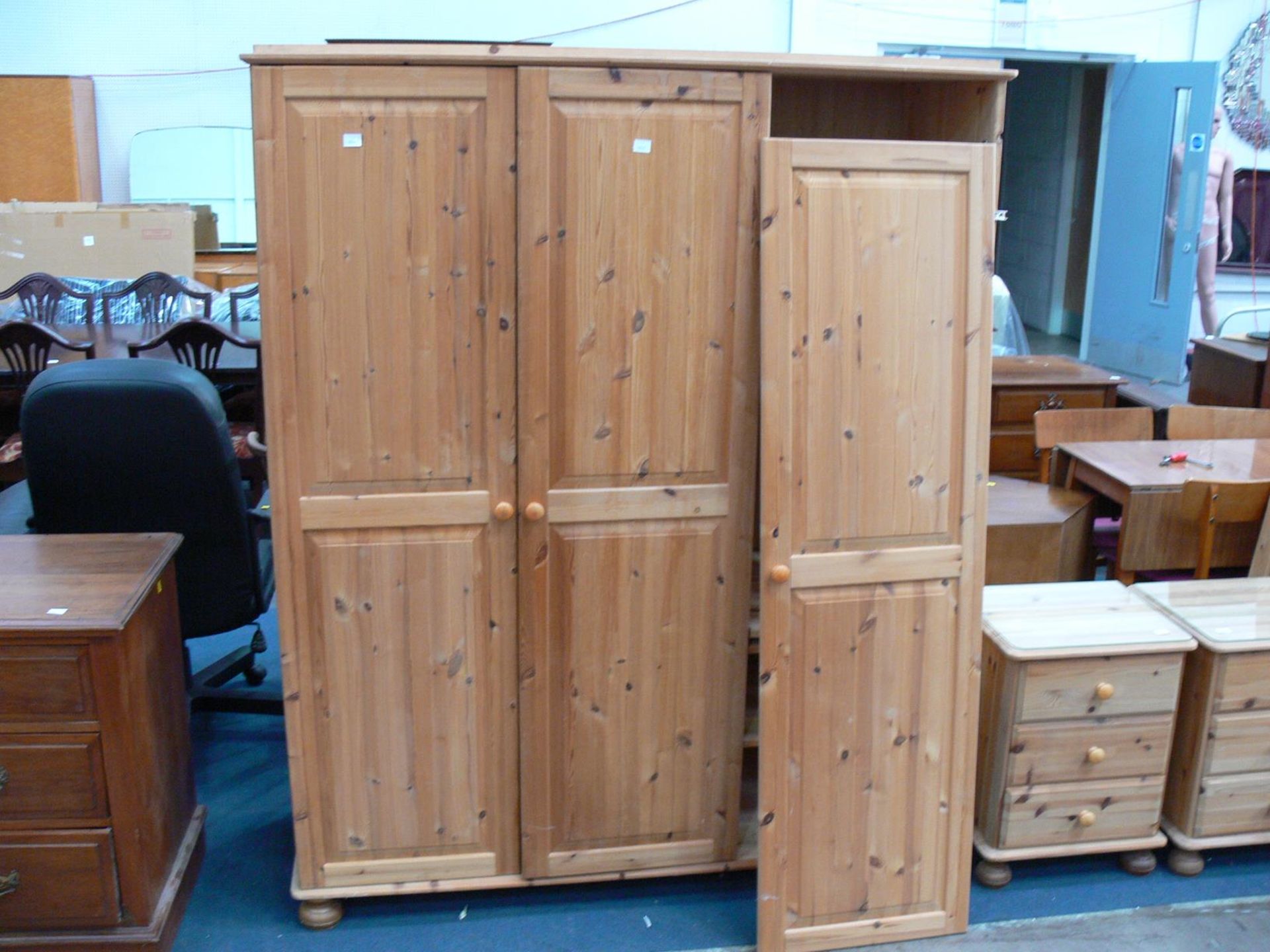 A three door pine wardrobe split two thirds and one third, with shelves to the right (H182cm W142.