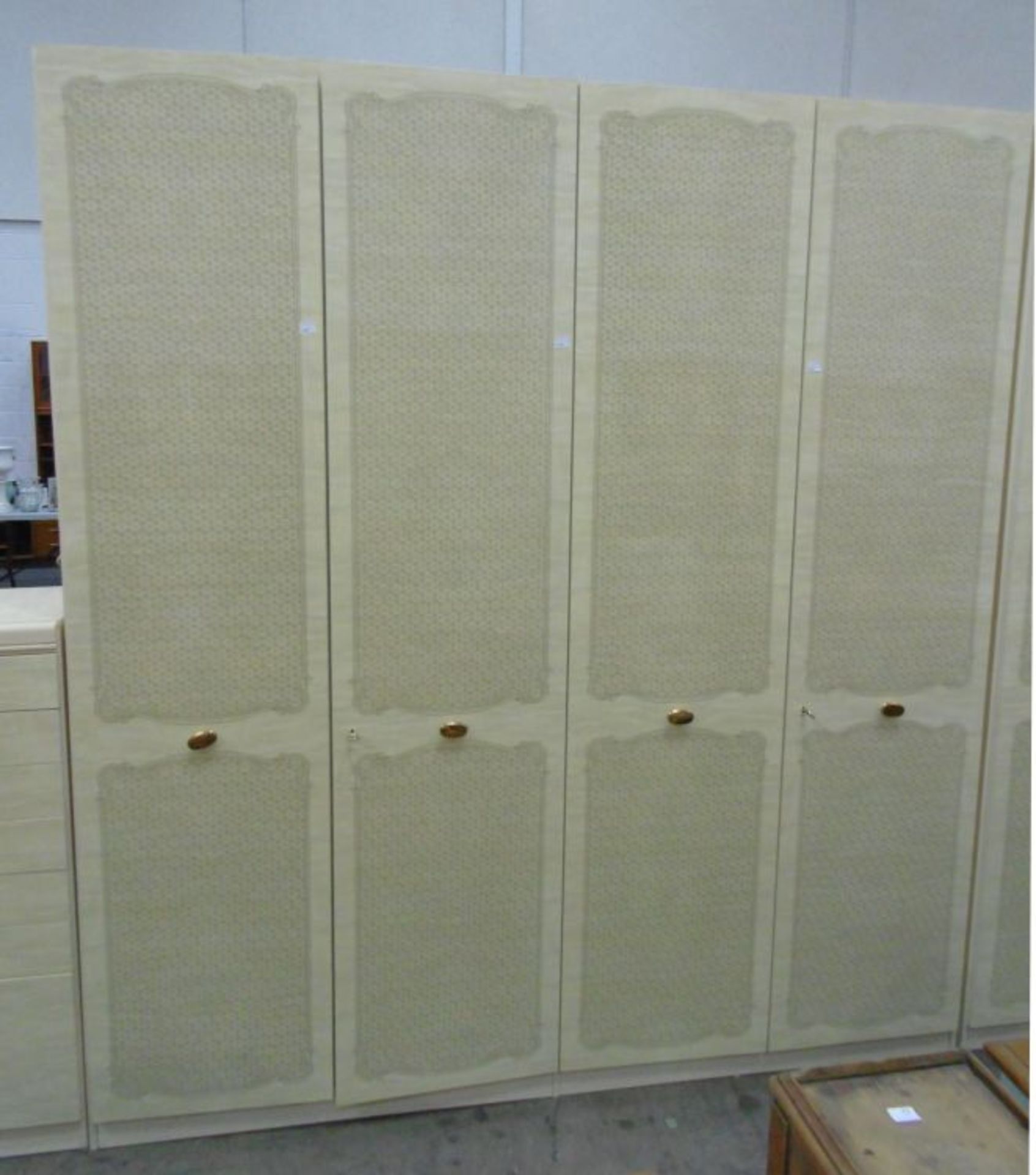 A substantial and tall figured cream melamine Wardrobe Unit comprising two double wardrobes