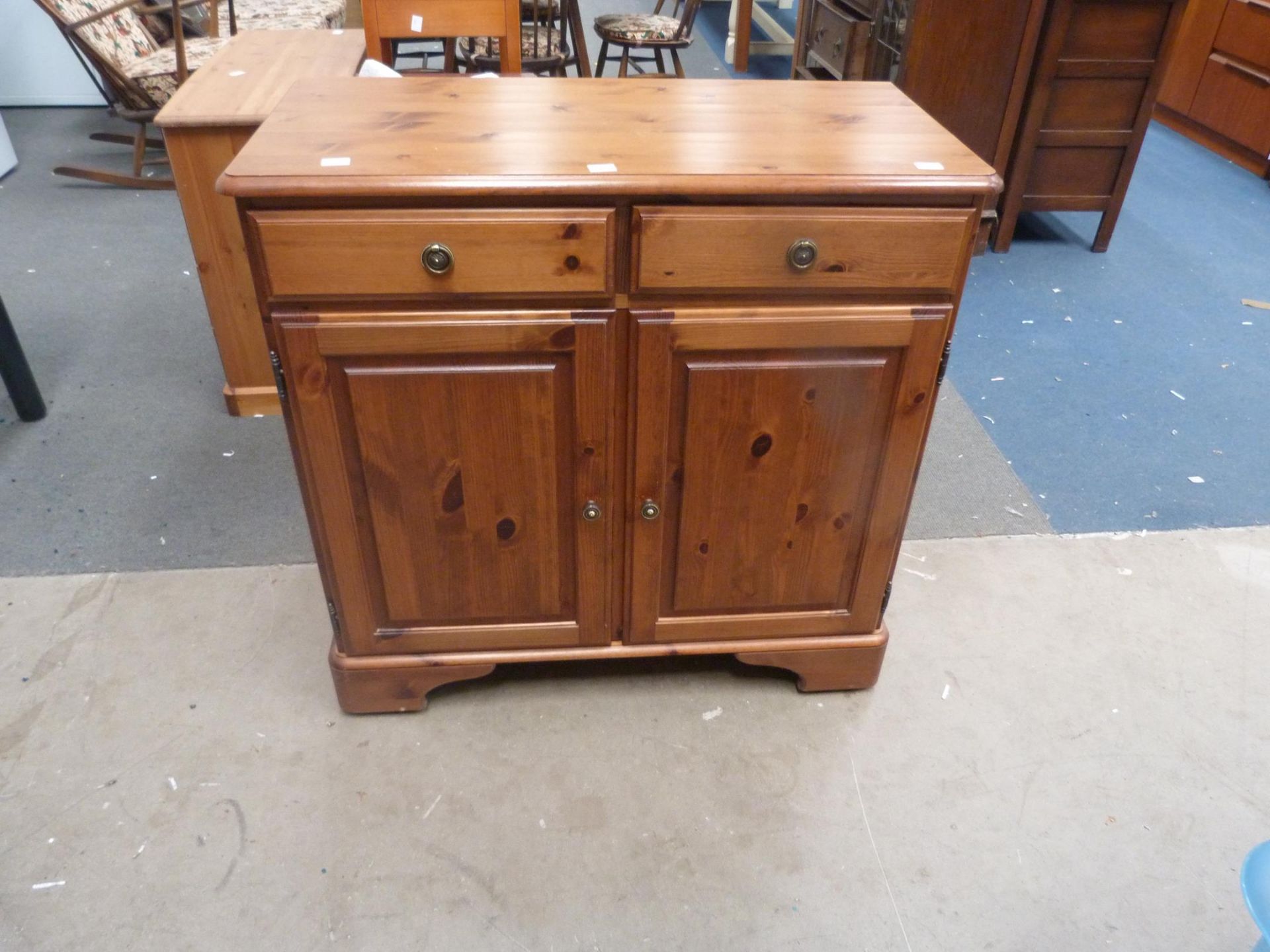 A Ducal Pine Sideboard with two drawers above cupboard with single shelf behind double doors on