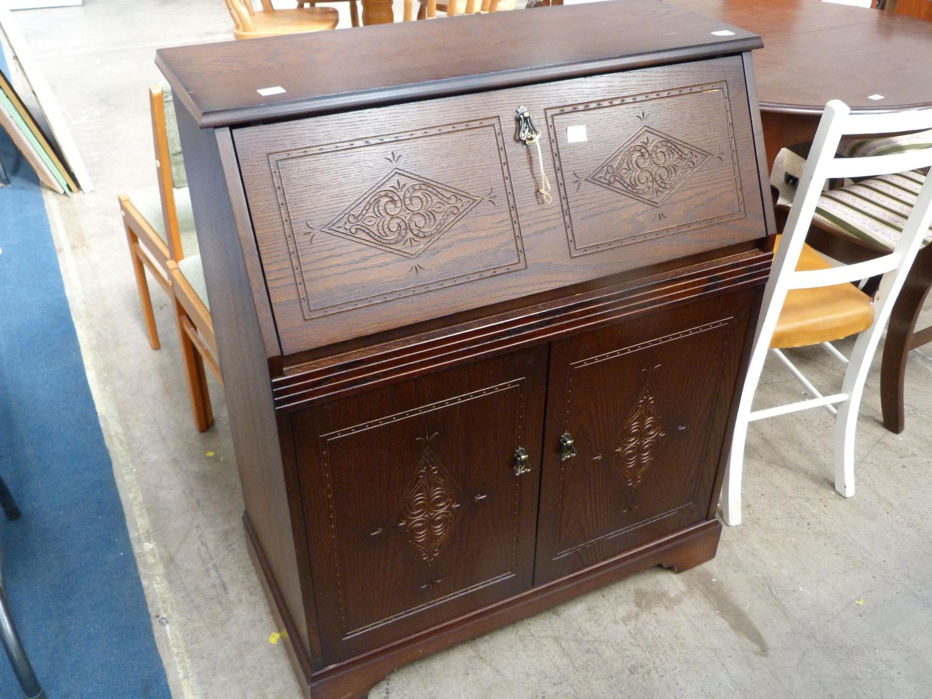 A Writing Desk with fitted interior and carved Front above cupboard with single shelf (H100.5cm,