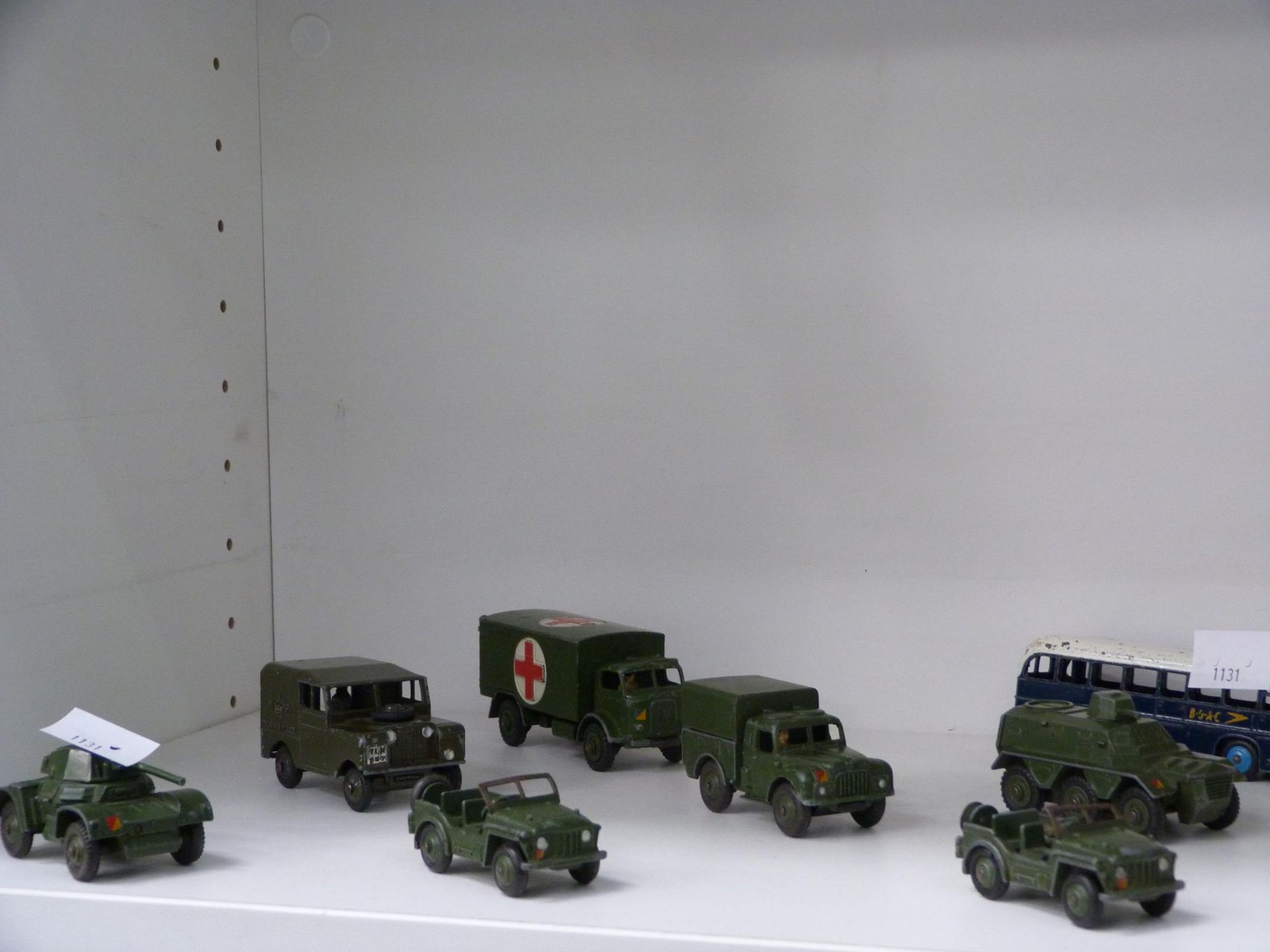 A shelf to feature a selection of Military Dinky Toys, a B.O.A.C Dinky Bus, Plastic Toy Soldiers and