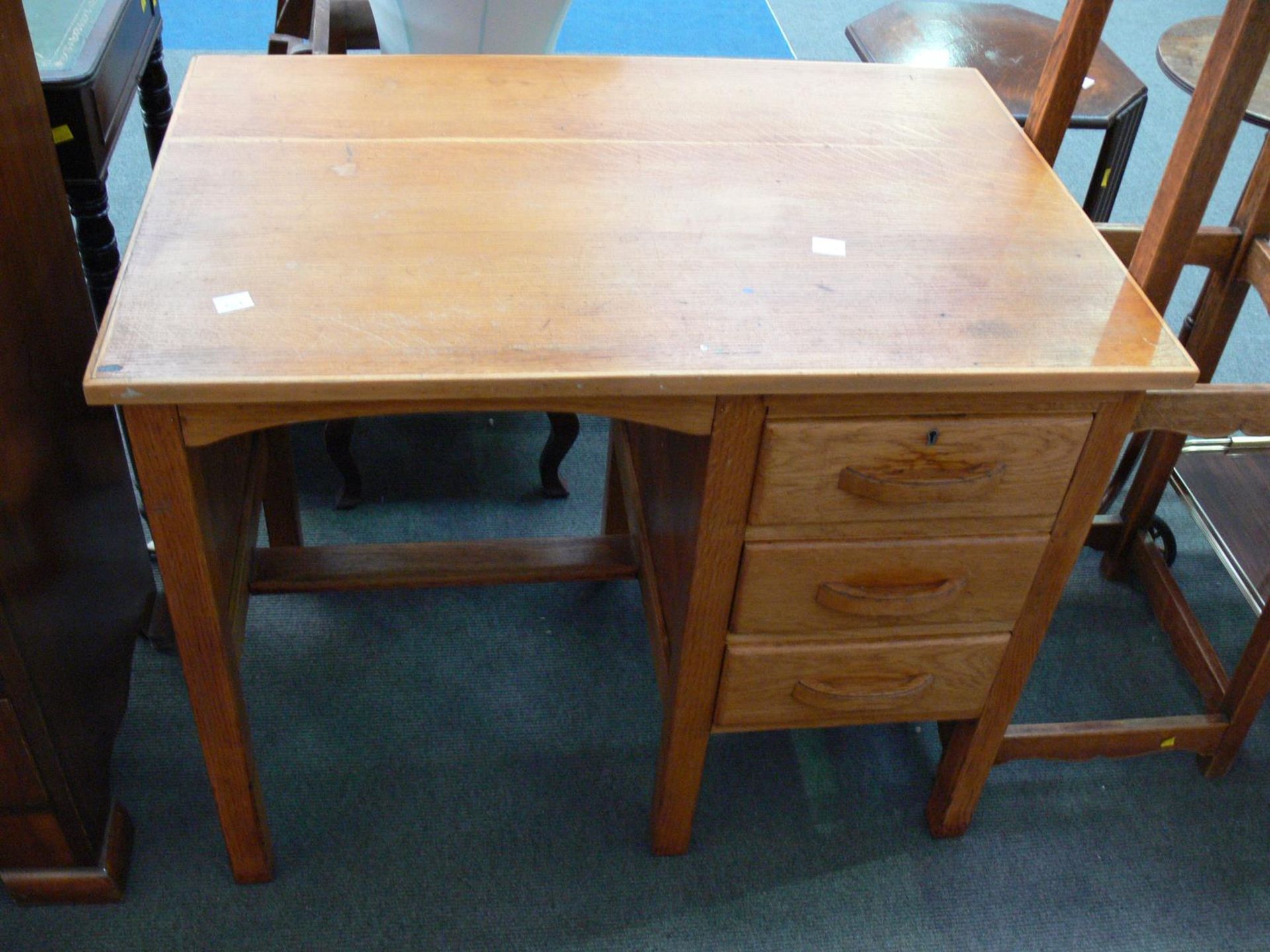 A small wooden Desk with column of three draws to the right with foot rest (H75cm W92cm D61cm). (