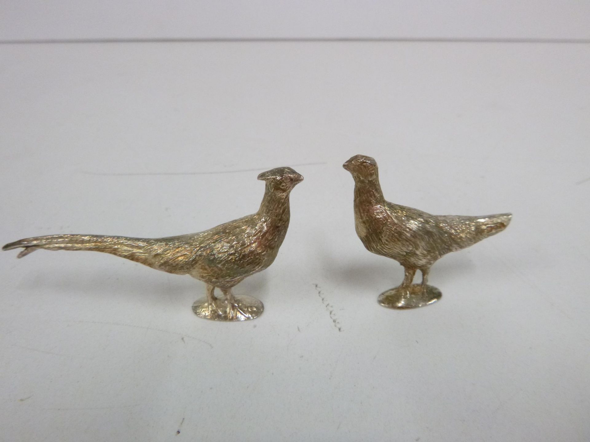 Three small Solid Silver Figures - Hen & Cock Pheasant & a Fox, London 1976 (2) and London 1973.