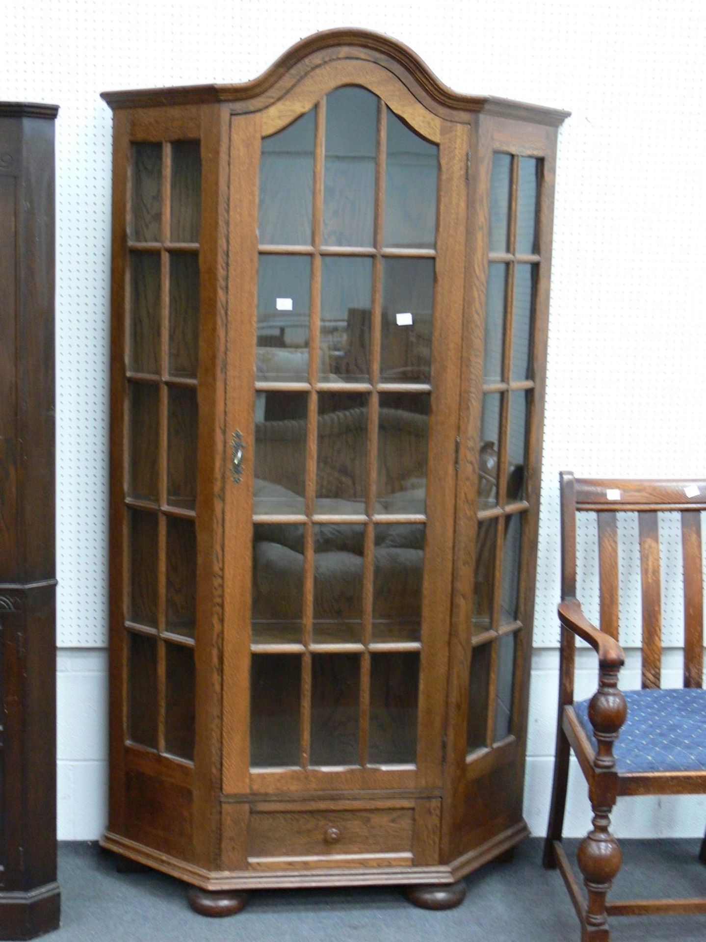 An Oak Standing Display Cabinet with lockable door, and single drawer below (H193cm W110cm