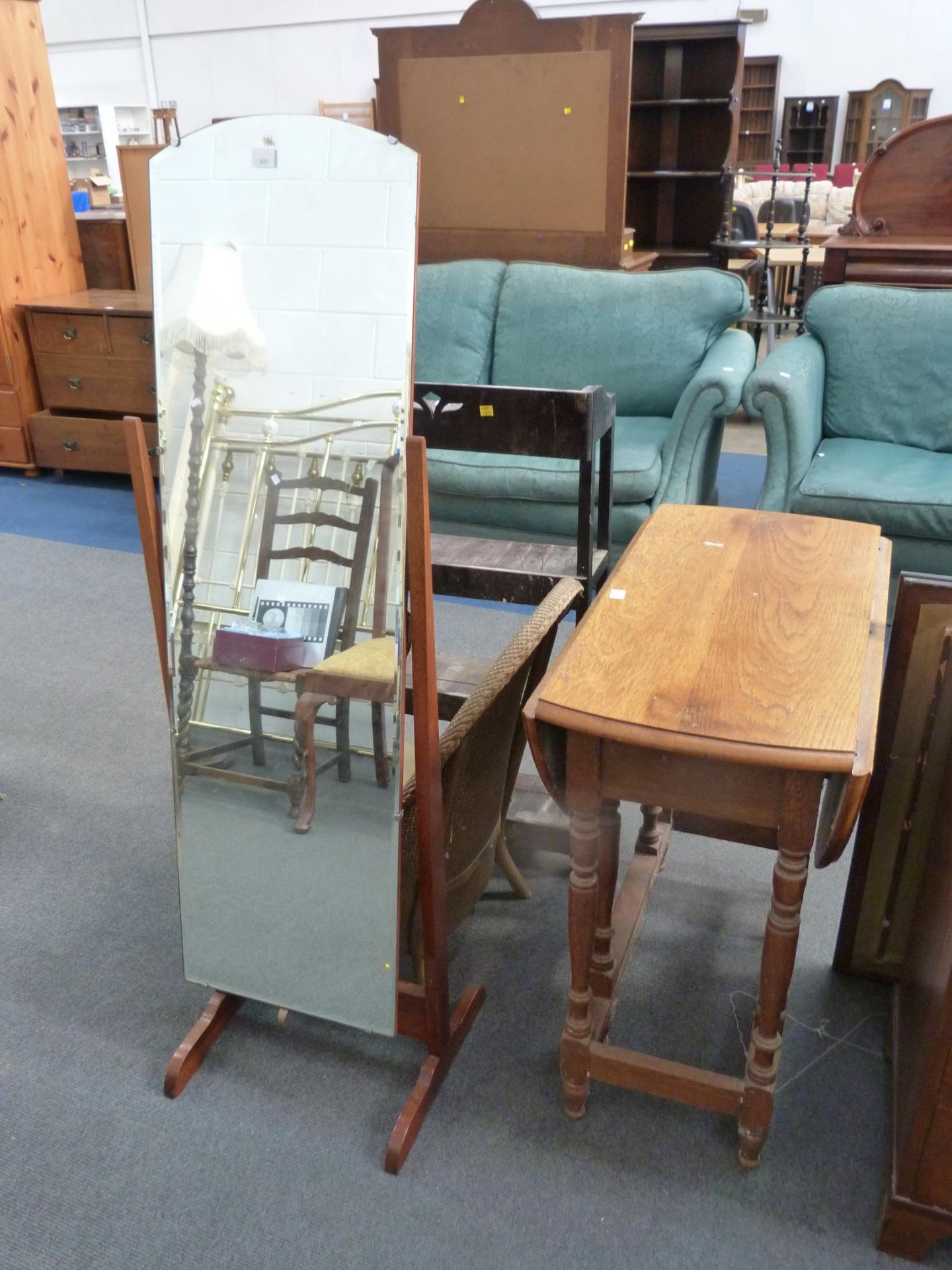 An Oak Oval Gateleg Dining Table, a Cheval Mirror, Open Bookcase and a Basket Chair (4) (Est. £
