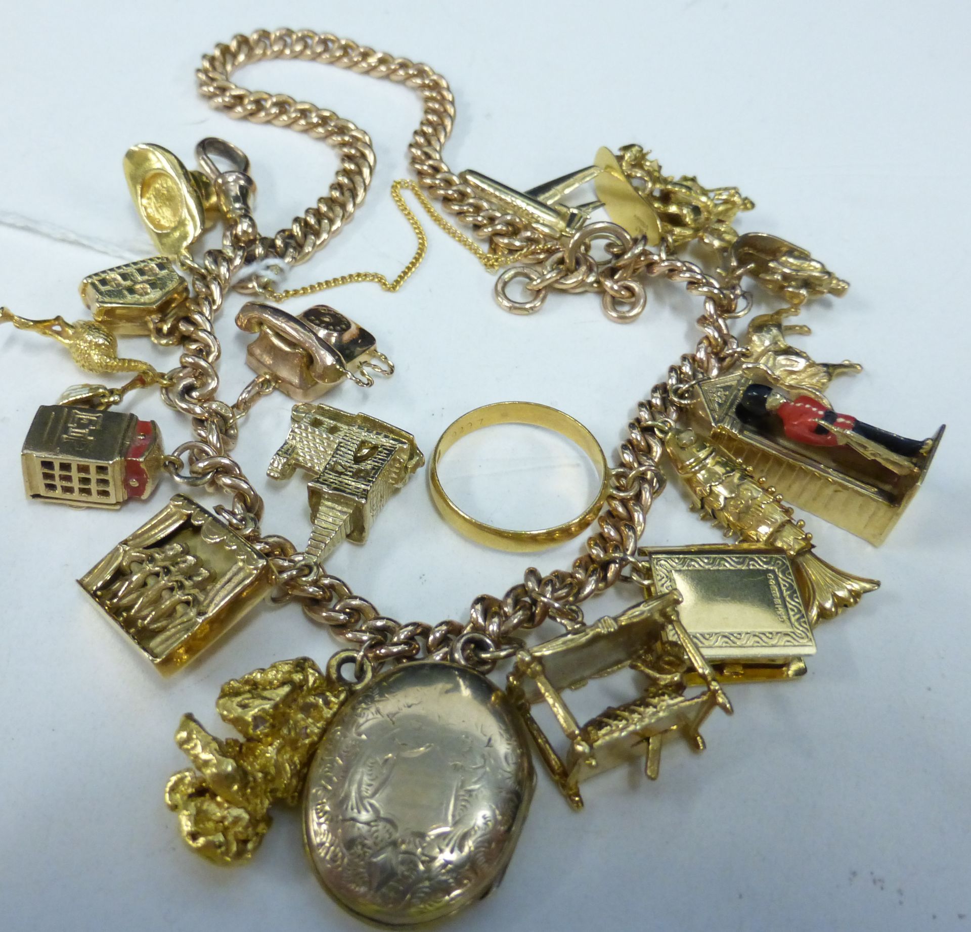 A 9ct Gold Watch Albert/Charm Bracelet Set with eighteen mostly 9ct charms (not all hallmarked)