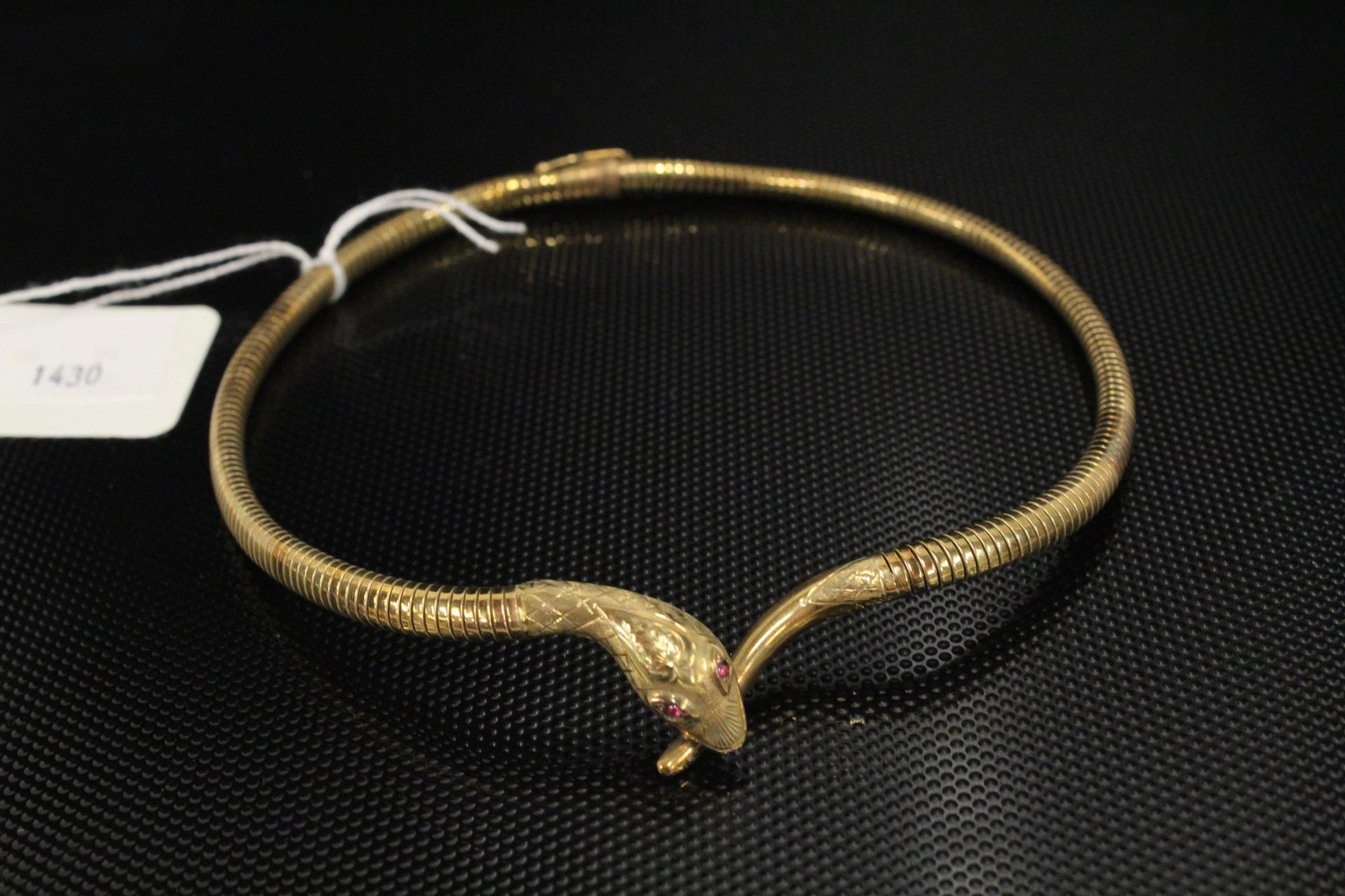 A 9ct Gold fancy Necklet as a snake set with Ruby (?) eyes. 30gms cased (Est.£300 - £400)